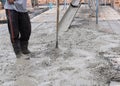 Construction workers spreading freshly poured concrete mix for home building