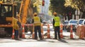 Construction Workers Standing Near Excavator and Traffic Cones Royalty Free Stock Photo
