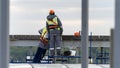 Construction workers in their work attire are installing fresh roofing components, power tools, and electric Royalty Free Stock Photo