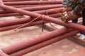 Construction workers are using grinding machines on large steel pipes. Used as a roof pole. Sparking while working Red painted Royalty Free Stock Photo