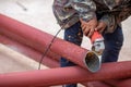 Construction workers are using grinding machines on large steel pipes. Used as a roof pole. Sparking while working Red painted Royalty Free Stock Photo