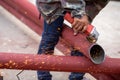 Construction workers are using grinding machines on large steel pipes. Used as a roof pole. Sparking while working Red painted Royalty Free Stock Photo