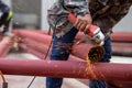 Construction workers are using grinding machines on large steel pipes. Used as a roof pole. Sparking while working Red painted Royalty Free Stock Photo