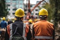 Construction workers wearing safety helmet and safety vest working on construction site, rear view of Construction workers at the Royalty Free Stock Photo