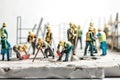 Construction workers wearing safety helmets and vests are tiling. Macrophotography tiny little workers. Generative AI