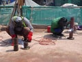 Construction workers welding pipes at the construction site. Royalty Free Stock Photo