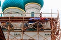 Construction workers working on high scaffolds during facade renovations of church in Tolga convent in Yaroslavl, Russia