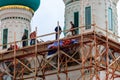 Construction workers working on high scaffolds during facade renovations of church in Tolga convent in Yaroslavl, Russia