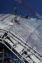 Construction workers working on the roof of a building tied with Royalty Free Stock Photo