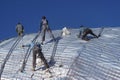 Construction workers working on the roof of a building tied with Royalty Free Stock Photo