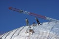 Construction workers working on the roof of a building tied with Royalty Free Stock Photo