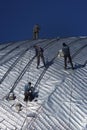 Construction workers working on the roof of a building tied with Royalty Free Stock Photo