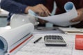 Construction working tool, calculator, blueprint and safety helmet on architect workplace desk