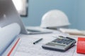 Construction working tool, calculator, blueprint and safety helmet on architect workplace desk Royalty Free Stock Photo