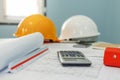 Construction working tool, calculator, blueprint and safety helmet on architect workplace desk Royalty Free Stock Photo