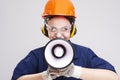 Construction Works Concepts. Caucasian Female Shouting Worker Posing with Megaphone In Front of Face and Wearing Hardhat for Royalty Free Stock Photo