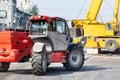 Constuction site heavy machinery industrial background. Telescopic handler vehicle and big mobile crane working at city building