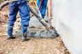 Constuction - worker laying cement or concrete with automatic pump