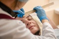 Doctor in latex gloves check patient face with ruler