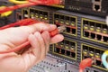 IT consultant connects a network cable into switch in datacenter Royalty Free Stock Photo