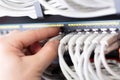 IT consultant connects a network cable into switch in large datacenter Royalty Free Stock Photo