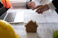 Consultant and engineer meeting about a building project on his blueprint and laptop