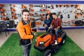 A consultant in a garden tools store shows a customer a lawn mower. Royalty Free Stock Photo