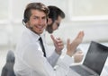 Consultant in headphones sitting at his Desk. Royalty Free Stock Photo