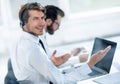 Consultant in headphones sitting at his Desk. Royalty Free Stock Photo