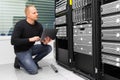 Consultant Using Laptop While Monitoring Servers In Datacenter Royalty Free Stock Photo