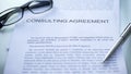 Consulting agreement lying on table, pen and eyeglasses on official document Royalty Free Stock Photo