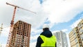 Consulting engineer at construction site holding blueprint in hand. Construction inspector. Construction site inspection