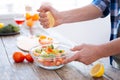 Male hands dressing fresh salad