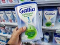 A consumer chooses a box of Gallia brand baby milk from the baby food section of a supermarket