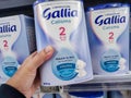 A consumer chooses a box of Gallia brand baby milk from the baby food section of a supermarket