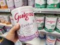 A consumer chooses a box of Guigoz brand baby milk from the baby food section of a supermarket