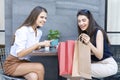 Consumer concept. Young women carry shopping bags. Happy woman paying in cafe by credit card and smart phone. Woman took a Royalty Free Stock Photo