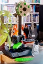 Consumer 3D-printer makes a bright green shoe sole in living room scene.