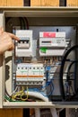 Turning circuit breaker in consumer unit with electrical meter. Royalty Free Stock Photo