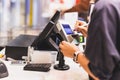 Consumers women signing on a touch screen of credit card sale transaction machine at supper market. Royalty Free Stock Photo