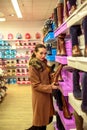 Consumerism, Christmas, shopping, lifestyle concept - young women shopping at shoes store. Royalty Free Stock Photo