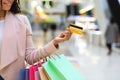 Consumerism Concept. Black woman with shopping bags and bank card in mall Royalty Free Stock Photo