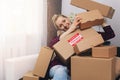 Consumerism concept - happy woman with cardboard boxes at home after shopping