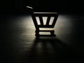 Consumerism. Model of shopping cart in the dark