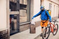Contacless delivery service during quarantine. Man delivers food and shopping bags during isolation Royalty Free Stock Photo