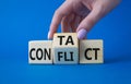 Contact and Conflict symbol. Businessman hand turns wooden cubes with words Contact and Conflict. Beautiful blue background. Royalty Free Stock Photo