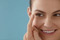 Contact eye lens. Smiling woman applying eye contacts closeup