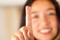 Contact lens on finger and beautiful woman smiling behind on gray background Royalty Free Stock Photo