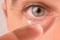 Contact lens on the finger and eye of man Royalty Free Stock Photo