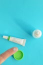 Contact lens on finger, tube of eye ointment and small bottle of eye drops on light blue background.Space for text on Royalty Free Stock Photo